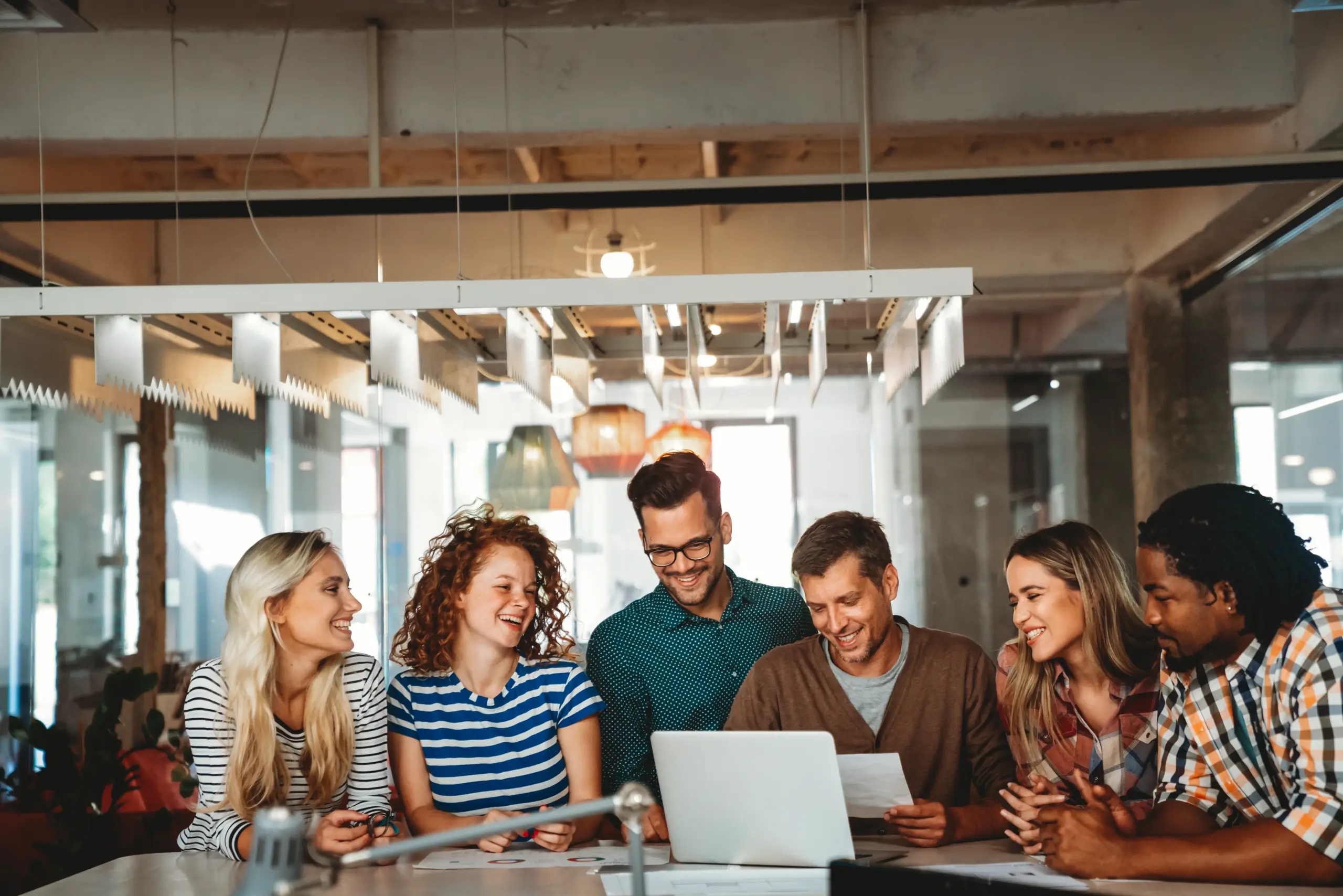 Foto von sechs Personen, die gemeinsam arbeiten und lachen